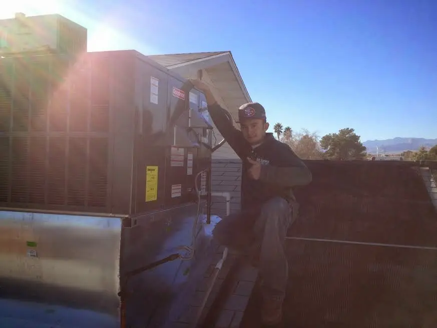 HVAC technician performing Heat Pump Repair on a rooftop unit in Hermiston